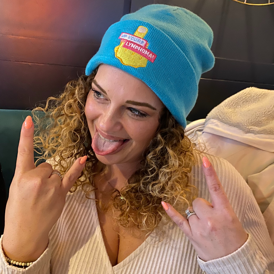 Woman giving the rock sign wearing a blue beanie